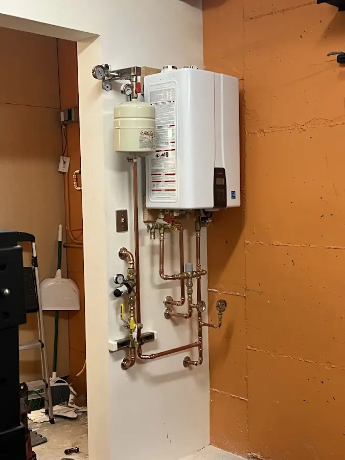 Plumbing technician inspecting water heater connections in Bermuda Run